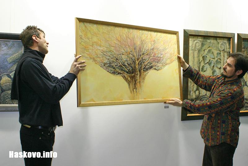 Симеон Тодев и директорът на галерията Владо Запрянов показват картината Клони и корени